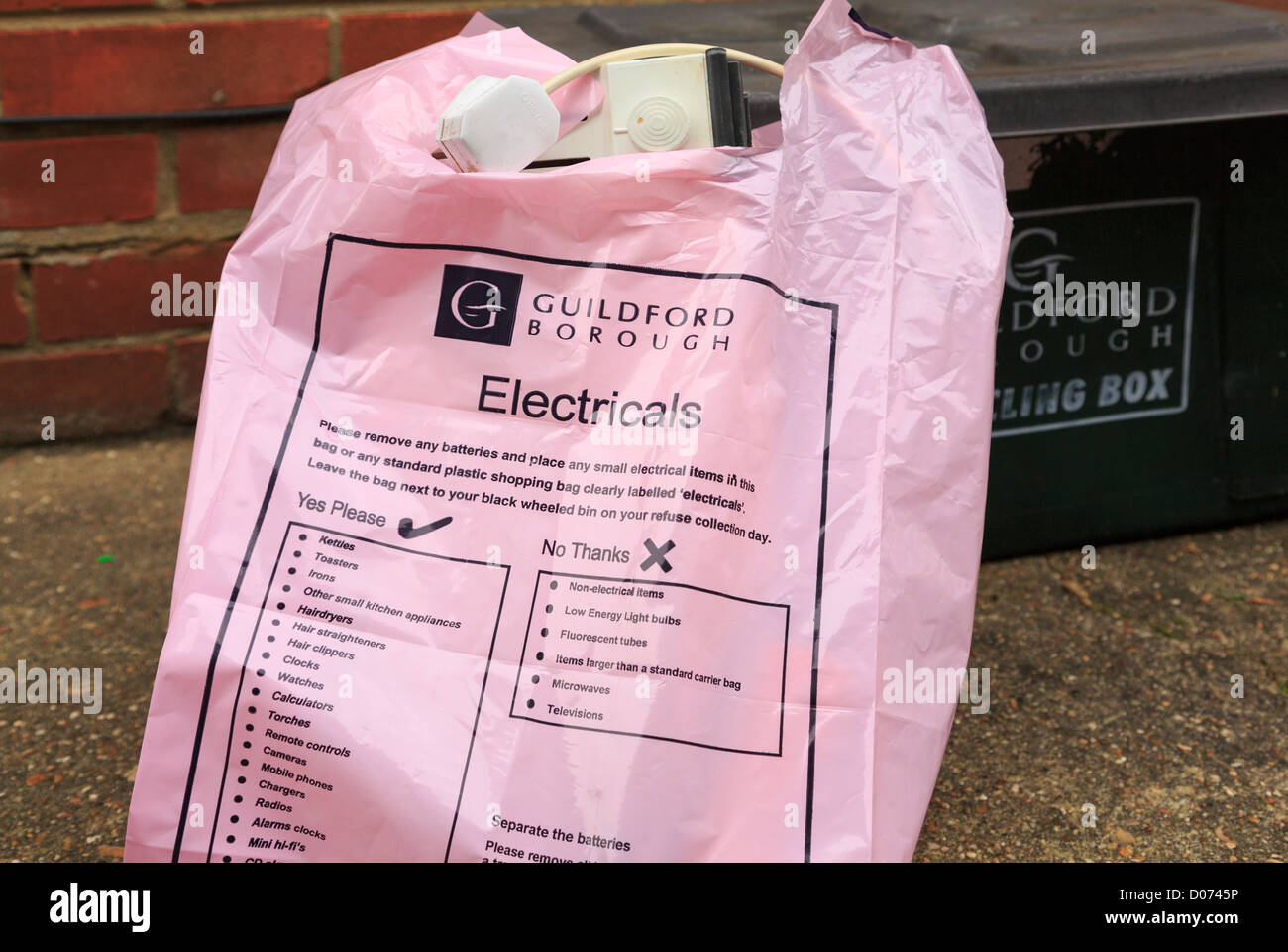 Guildford Borough consiglio di plastica rosa sacchetto di riciclo per uso domestico electricals al di fuori di una casa nel Surrey, Inghilterra, Regno Unito, Gran Bretagna Foto Stock