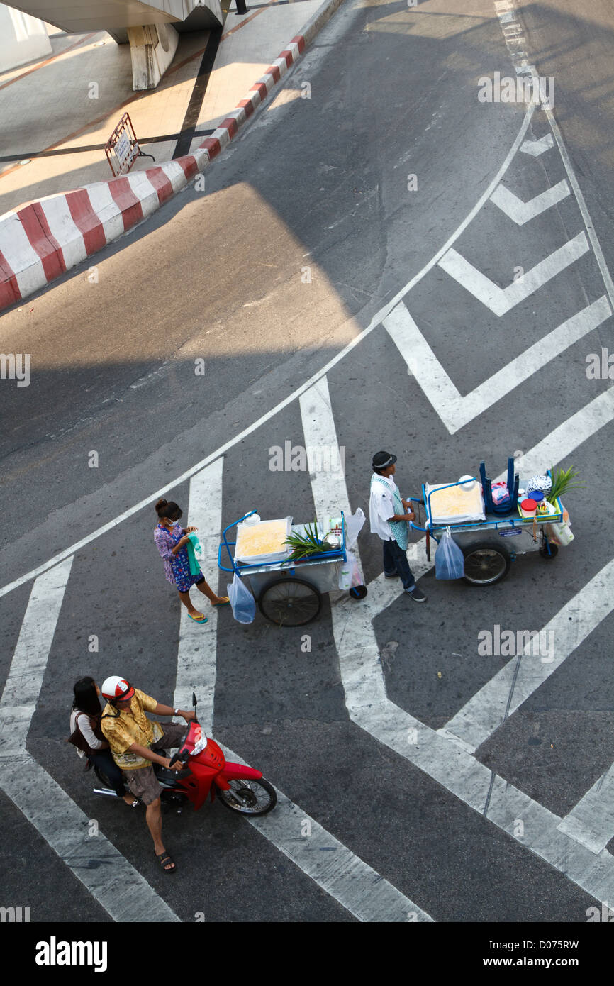 Il cibo e il venditore e le motociclette su una strada che attraversa a Bangkok, in Thailandia Foto Stock