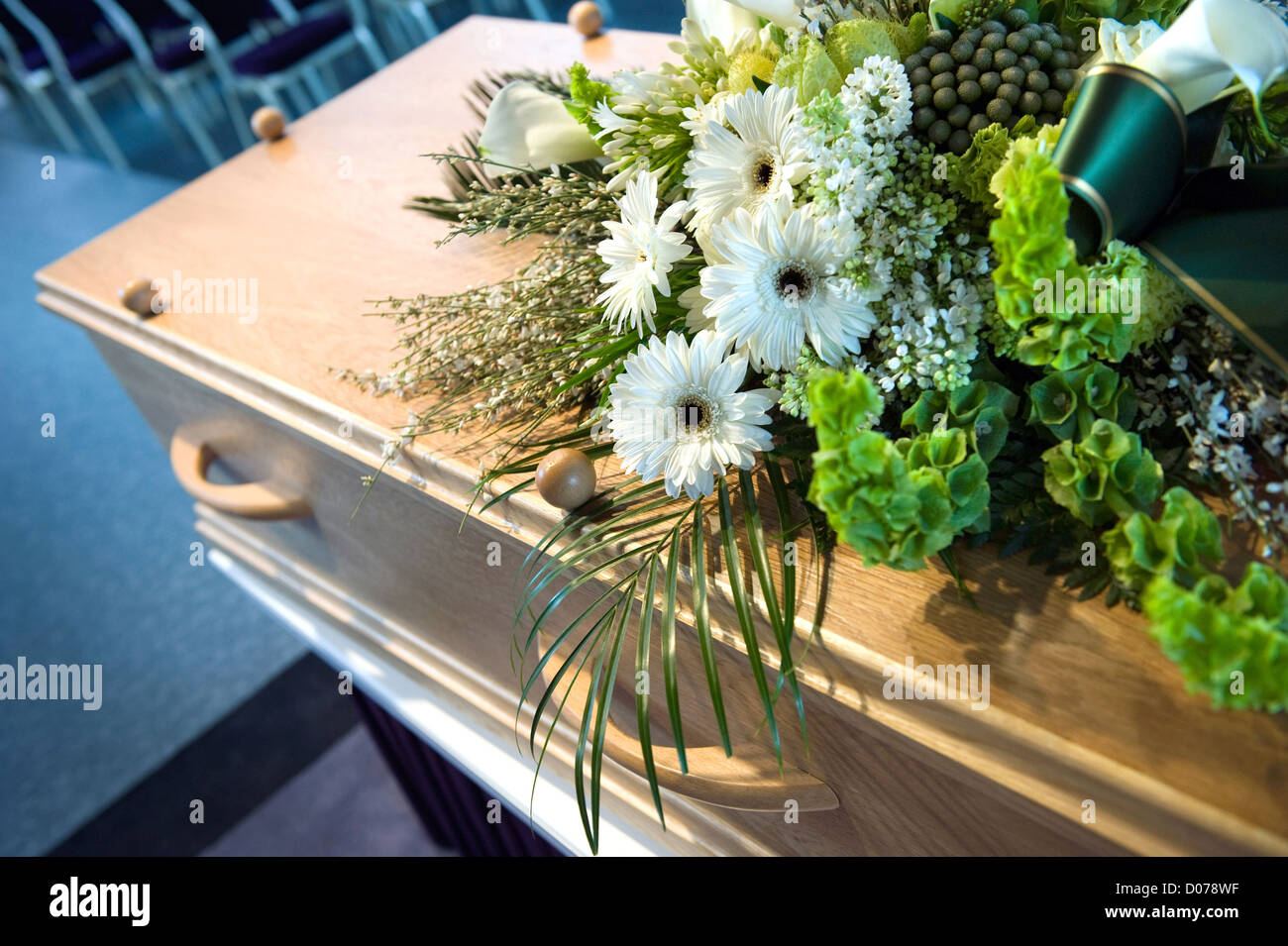 Una bara con un omaggio floreale in una camera mortuaria Foto Stock