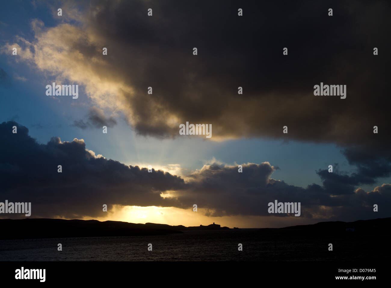 Nel tardo pomeriggio il sole invernale e nuvole sopra l'isola di Vaila sulle Isole Shetland Foto Stock