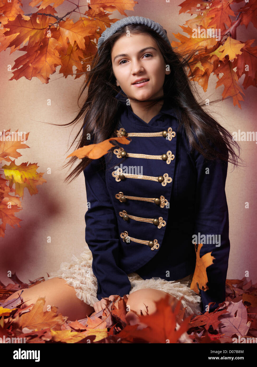 Ragazza seduta su caduto foglie di autunno autunno artistico ritratto di moda Foto Stock