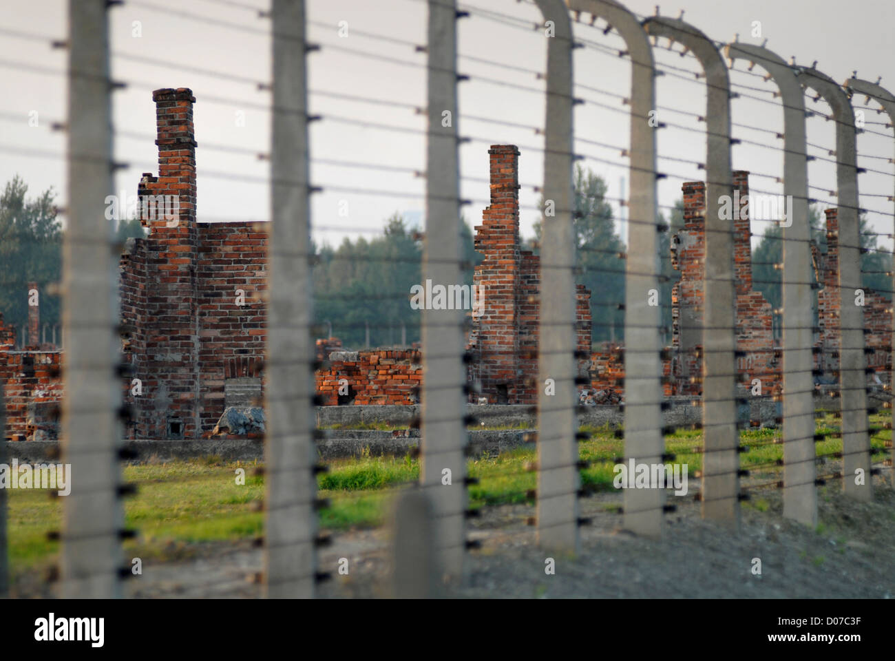 Ciminiere dietro il recinto con filo in Auschwitz Birkenau Foto Stock