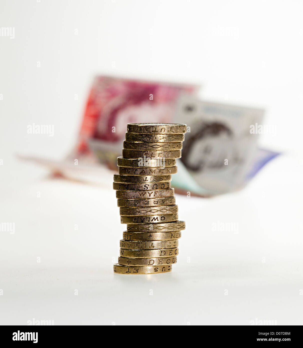 Sterlina inglese di denaro con cancelletto monete in una pila e le banconote in distanza REGNO UNITO Foto Stock