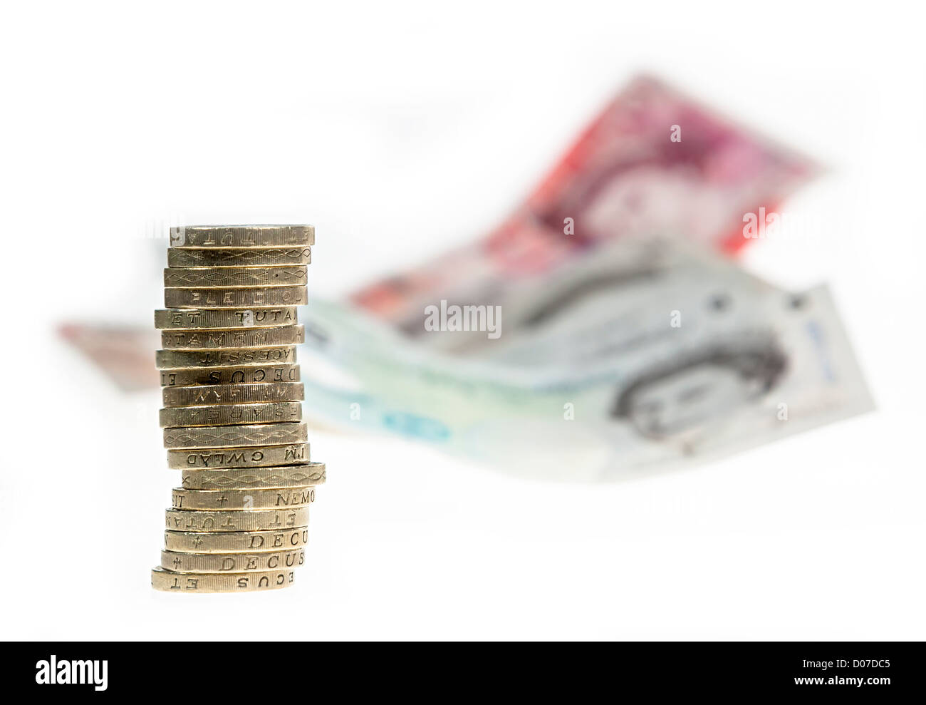 Sterlina inglese di denaro con cancelletto monete in una pila e le banconote in distanza REGNO UNITO Foto Stock