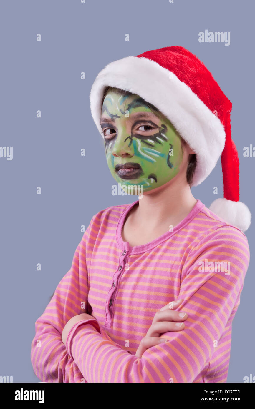 Una bambina indossa un cappello da Babbo Natale e ha volto la vernice  simile a il Grinch Foto stock - Alamy