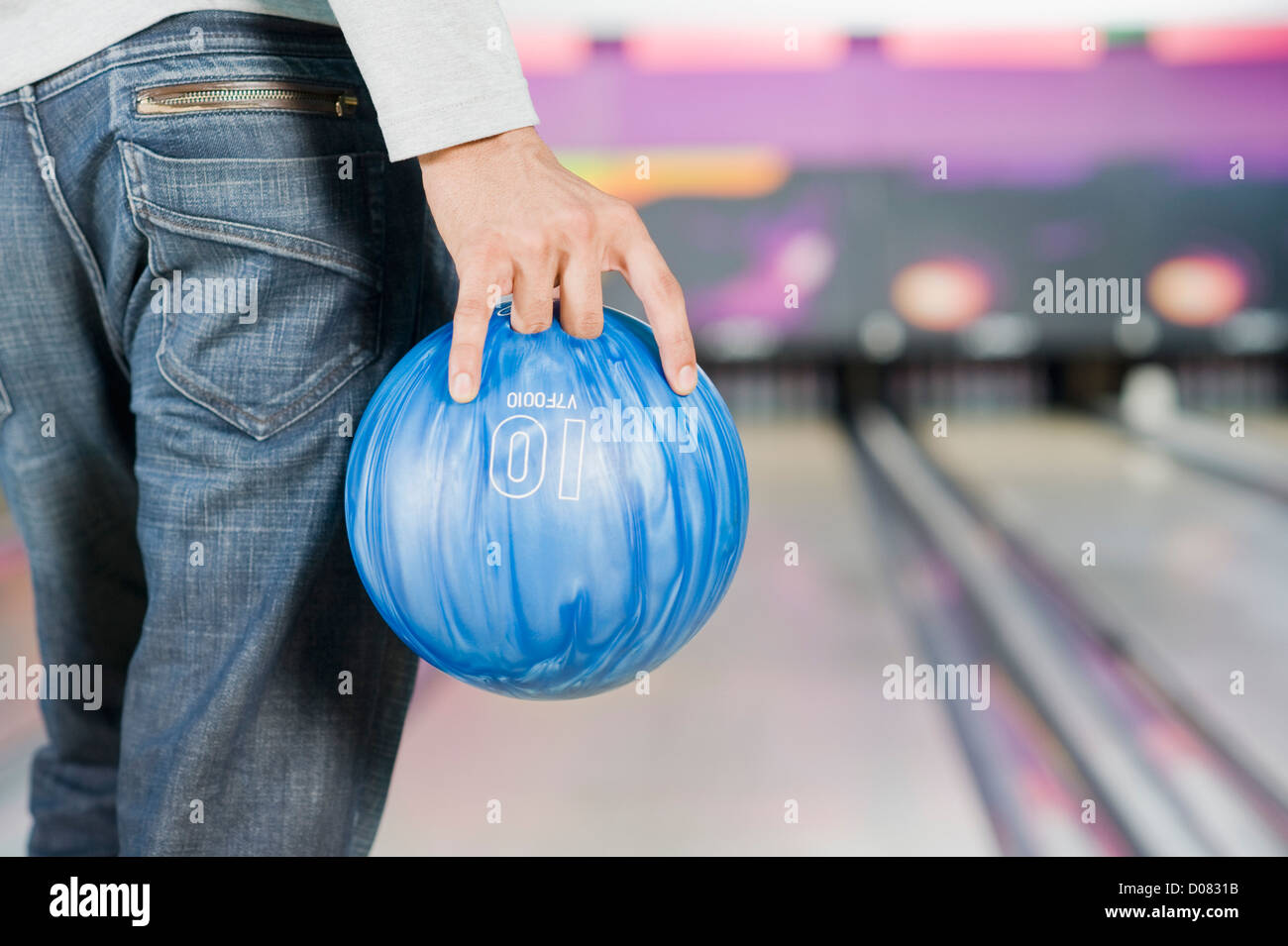 Giovane uomo in possesso di una palla da bowling in un impianto da bowling  Foto stock - Alamy