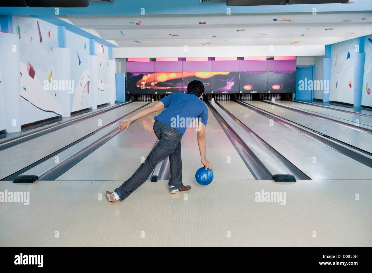 Giovane uomo giocando ten pin bowling Foto Stock