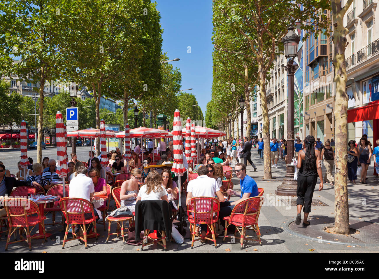 La gente seduta a una caffetteria sulla famosa strada dello shopping di Avenue des Champs Elysees Parigi Francia EU Europe Foto Stock