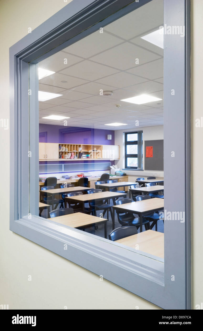 Guardando attraverso una finestra dal corridoio in una classe di una moderna scuola secondaria. Foto Stock