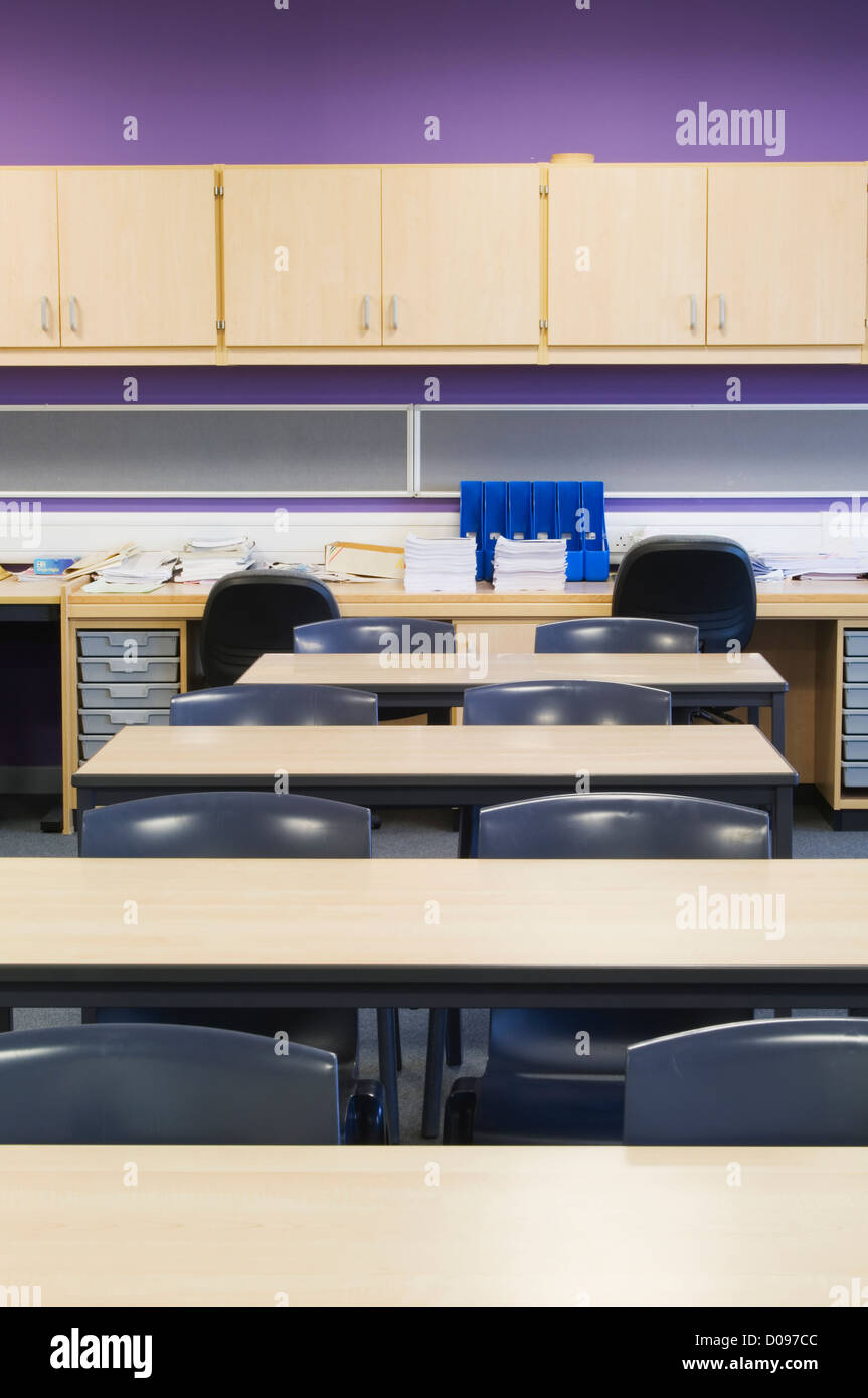 Interno di una classe in una moderna scuola secondaria con scrivanie e sedie e montato a parete armadi. Foto Stock