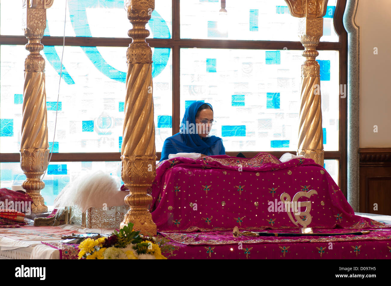 Granthi femmina la lettura del Guru Granth Sahib su Manji Sahib nel Darbar Sahib in Guru Nanak Gurdwara Darbar Gravesend Kent REGNO UNITO Foto Stock