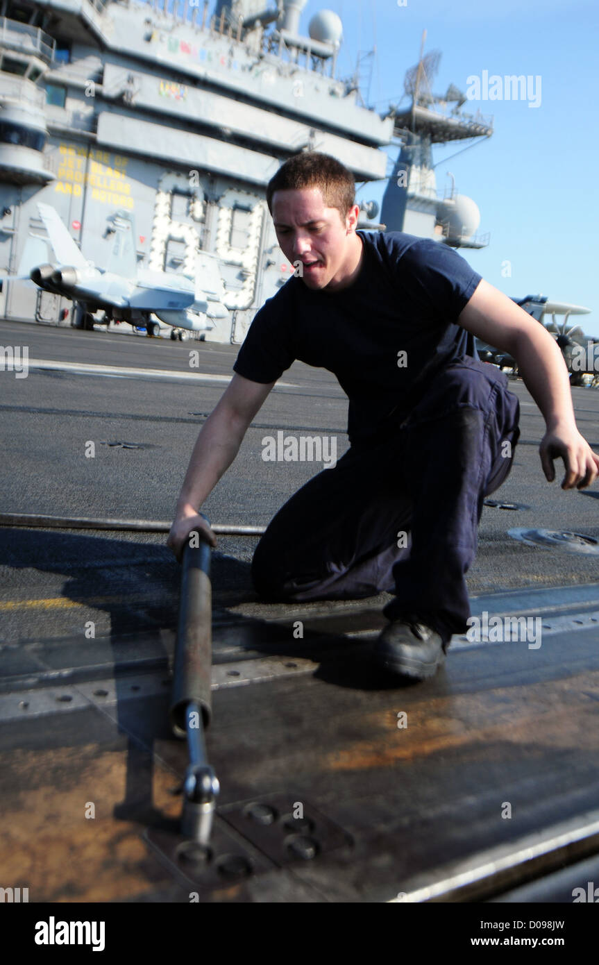 L'Airman Christopher Miller stringe un bullone su una catapulta a bordo della USS Dwight D. Eisenhower (CVN 69) durante il suo dispiegamento nell'area di responsabilità della 5th Fleet. Questo compito rientra nel garantire la preparazione operativa della nave alle operazioni di sicurezza. Foto Stock