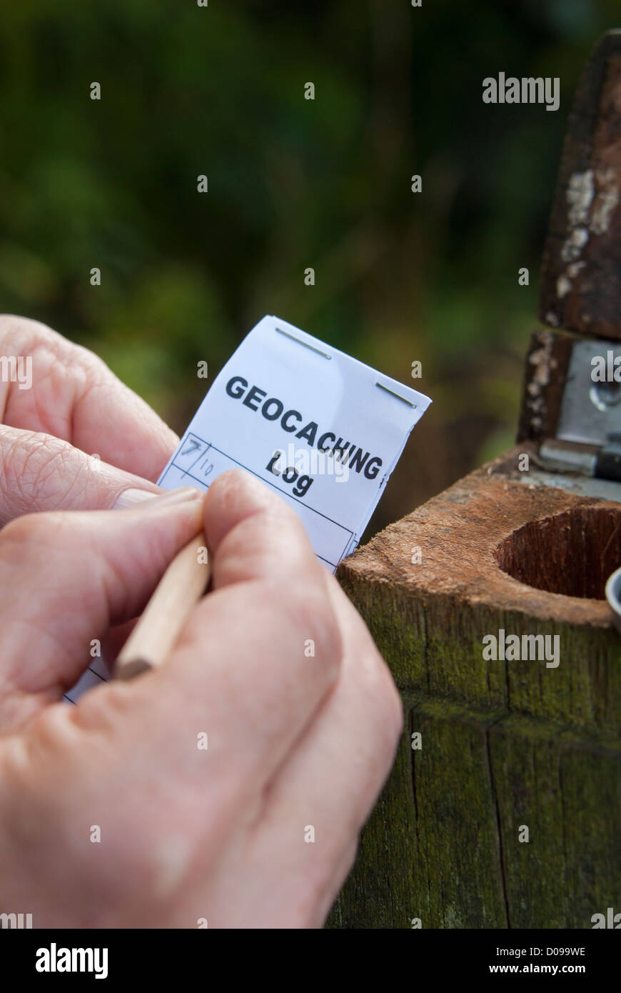 Il riempimento del registro di geocache dopo aver trovato la cache. Geocaching, Sheffield South Yorkshire, Inghilterra. Foto Stock