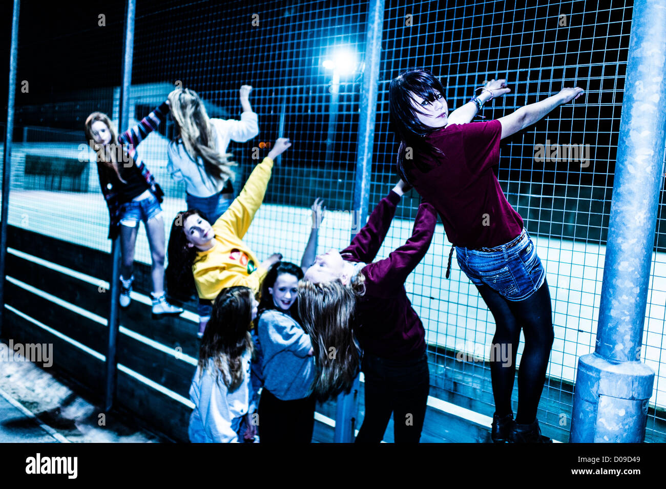 Un gruppo di 14 anni 15 ragazze adolescenti amici assieme al di fuori di notte REGNO UNITO Foto Stock