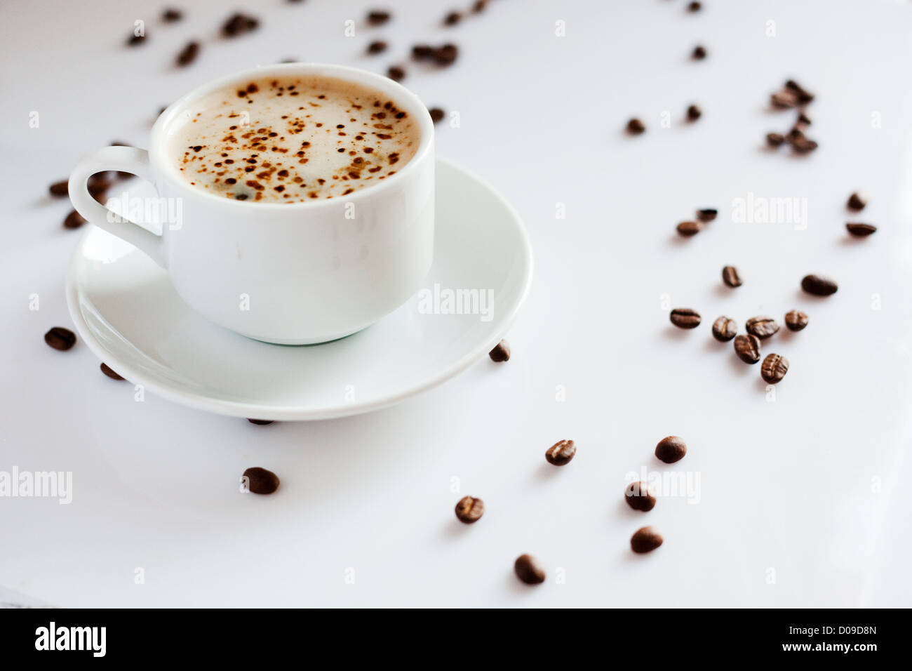Tazza di cappuccino caldo e i chicchi di caffè su sfondo bianco Foto Stock