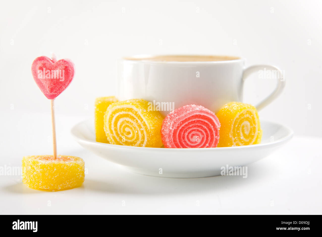 Tazza di cappuccino con caramelle su sfondo bianco Foto Stock