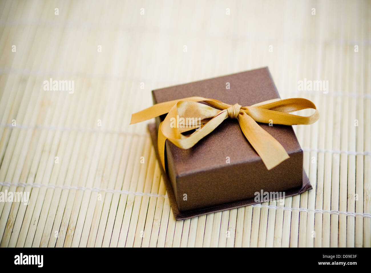 Regalo in piccola scatola marrone dorato con archetto Foto Stock