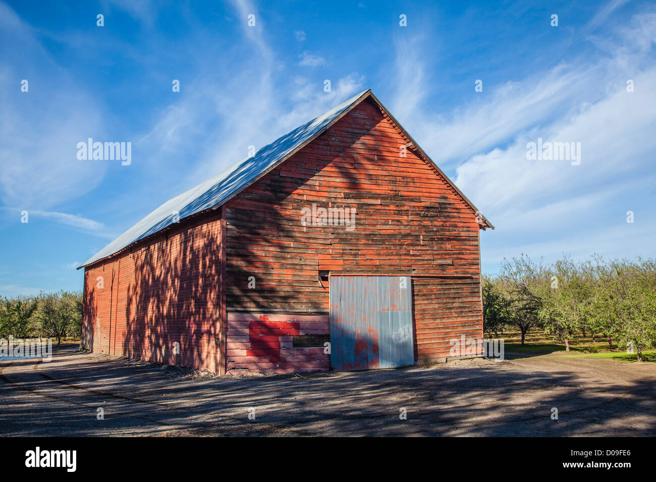 Ingresso anteriore del granaio rosso con weathered schierandosi in legno e color argento metallico ondulato porta scorrevole in Chico, California. Foto Stock