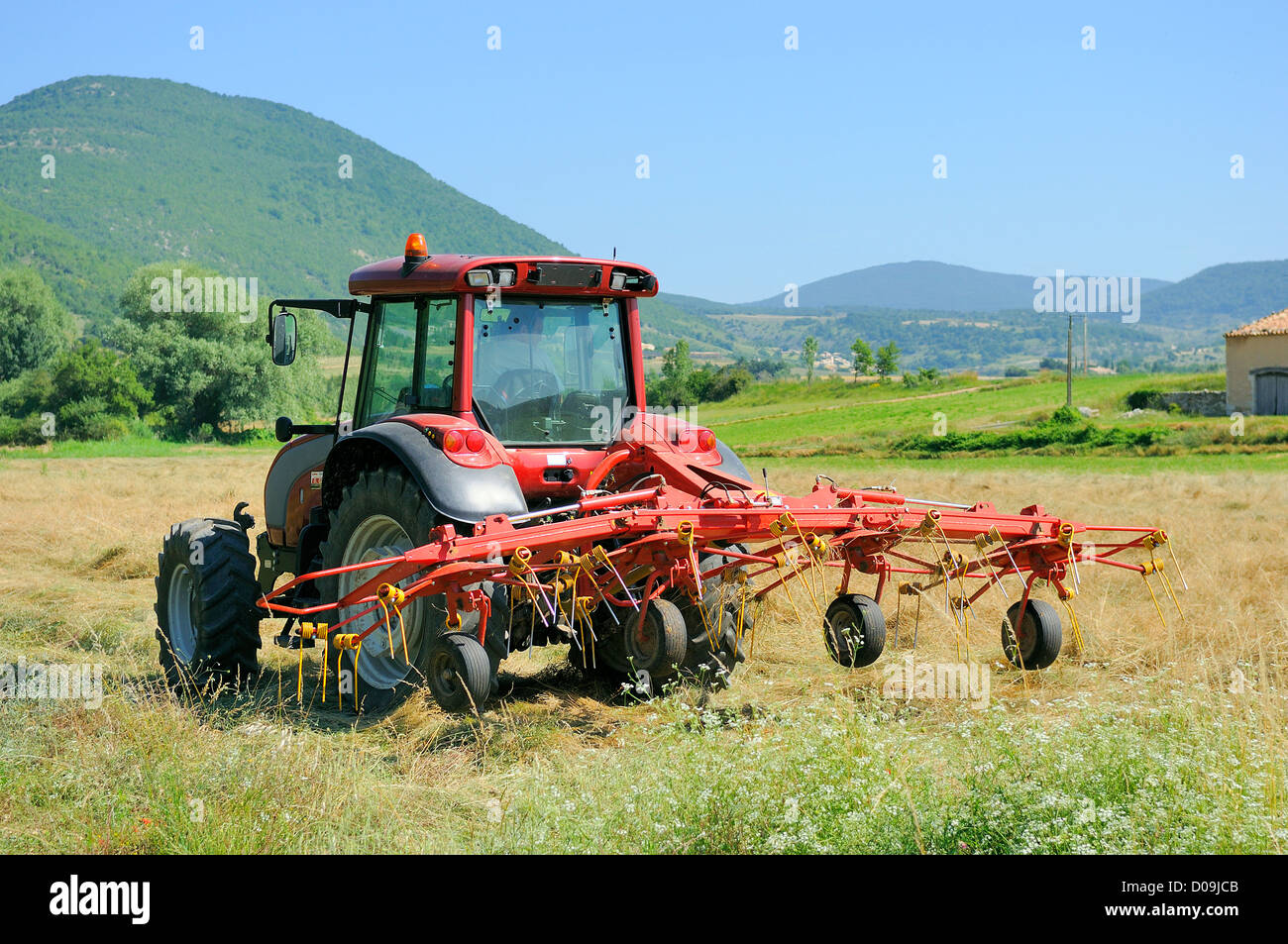 Le piccole aziende agricole con il trattore e aratro nel campo Foto Stock