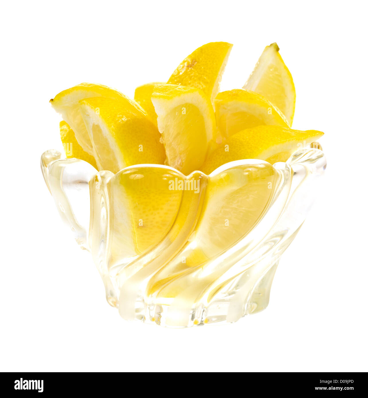 Un gruppo di spicchi di limone in un cristallo al piombo ciotola di vetro su uno sfondo bianco. Foto Stock