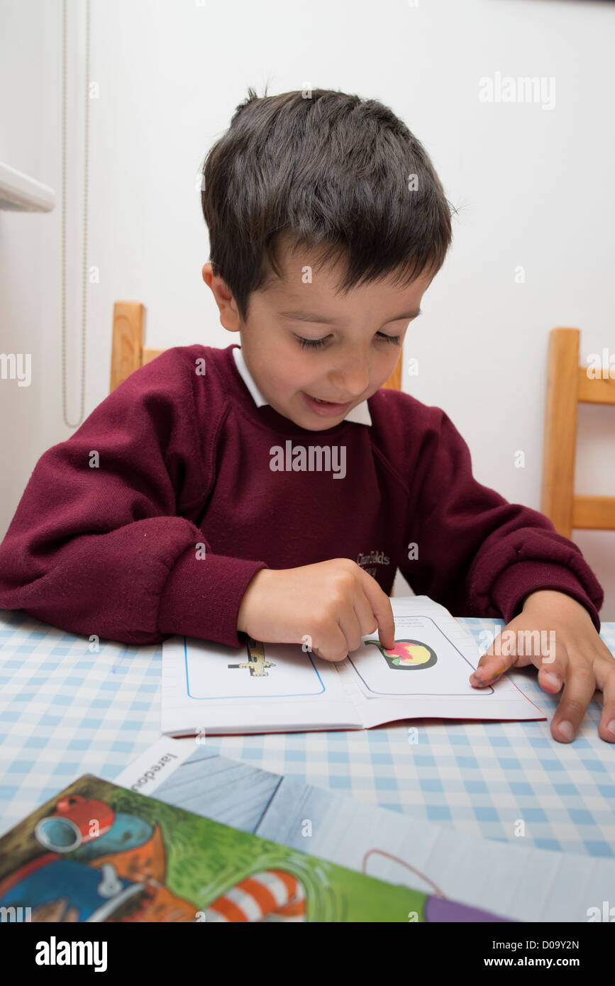 Ragazzo,5 anni,nella scuola primaria uniformi,imparare l'alfabeto Foto Stock