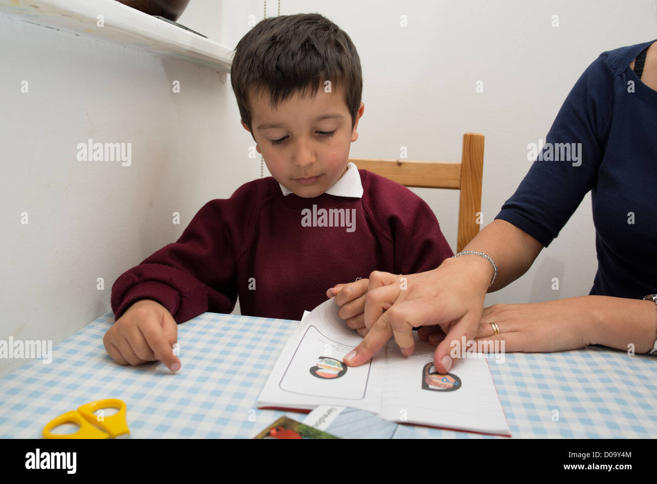 Madre di tutoraggio una primaria scolaro a casa Foto Stock