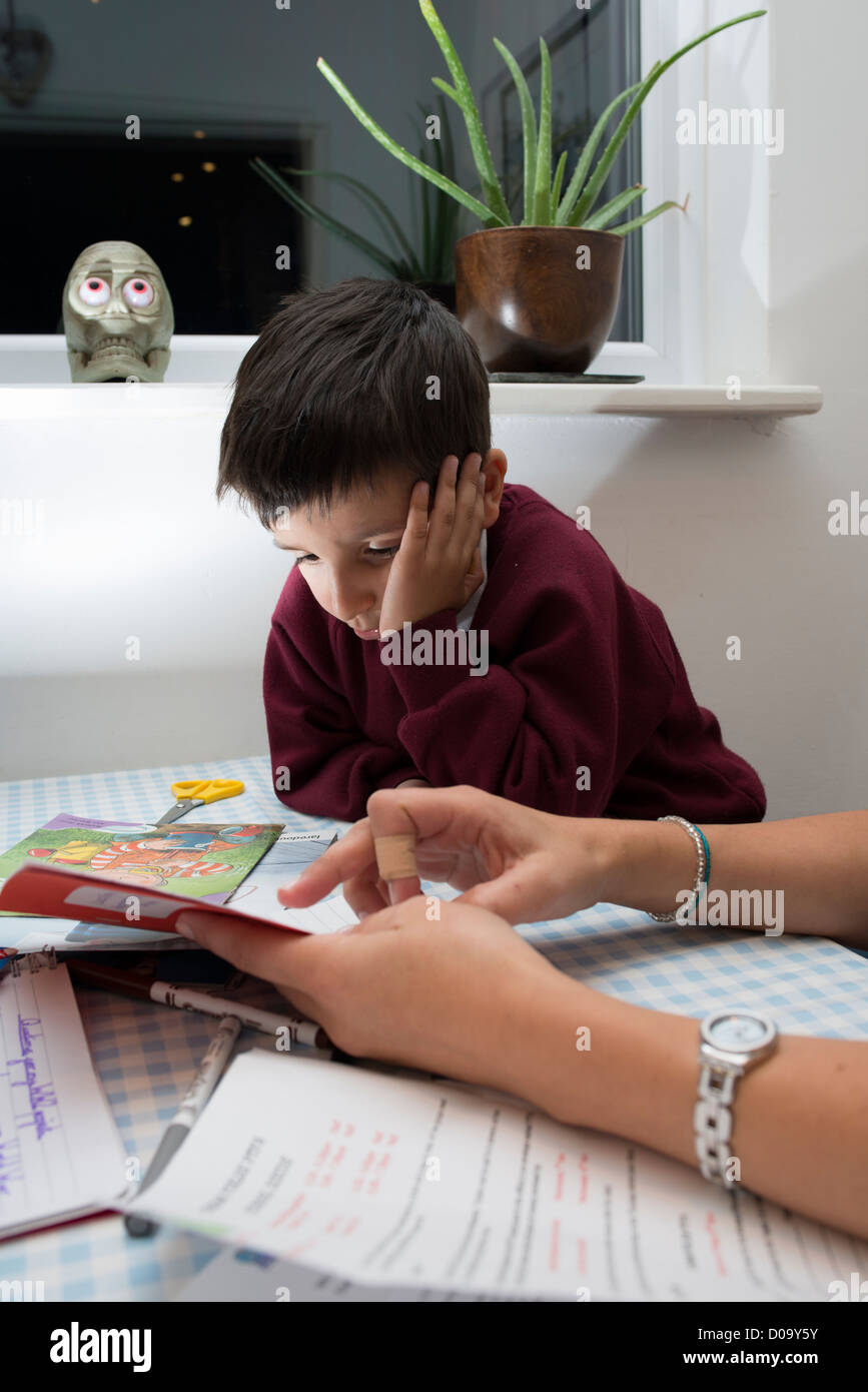 Madre di tutoraggio una primaria scolaro a casa Foto Stock