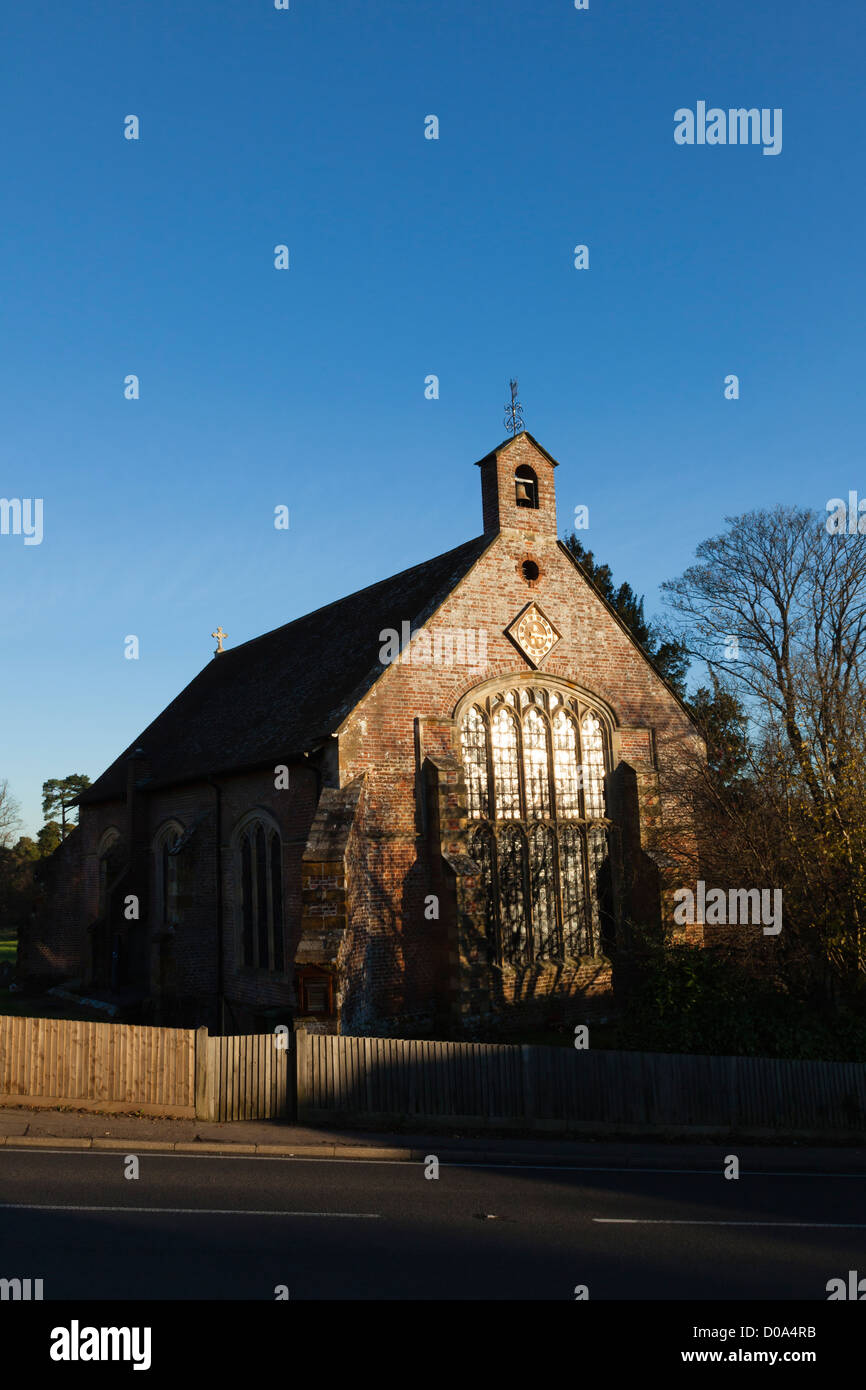 Graziosa cappella con vetrate colorate e inusuale orologio nel grazioso villaggio di Groombridge, REGNO UNITO Foto Stock