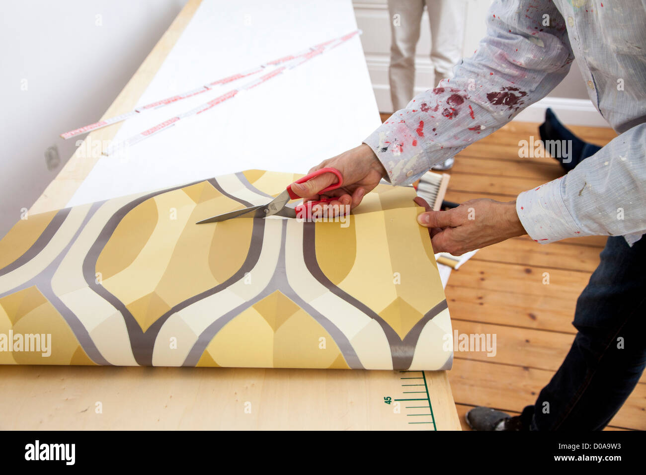 Giovane moglie sta rinnovando la sua casa. Paperhanging, nuovo sfondo. Fai da te. Foto Stock