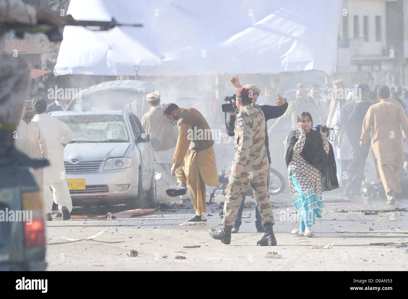 Il personale addetto alla sicurezza e le persone si radunano presso il sito dopo la bomba che è stata piantata su un ciclo di Shahbaz città di Quetta Mercoledì, Novembre 21, 2012. Almeno sette persone uccise tra cui tre FC personale e più di sedici feriti in esplosione, personale di FC sono stati presi di mira in attacco. Foto Stock