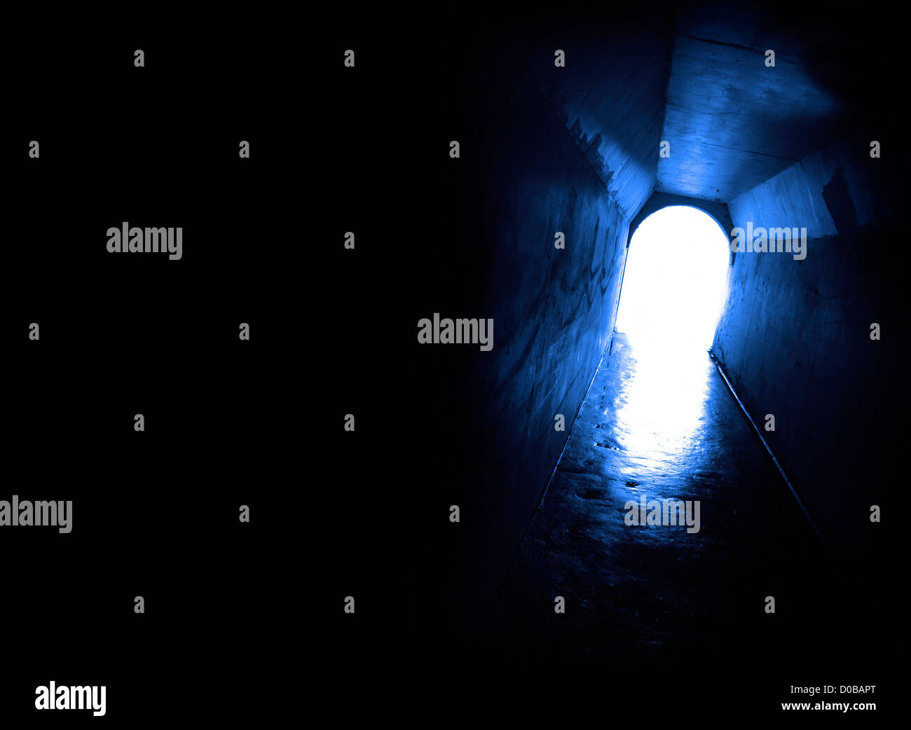 Un tunnel lungo la passerella con luce bianca alla fine Foto Stock