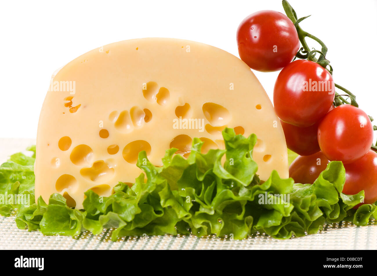 Una gialla Formaggio con fori e di pomodori ciliegini Foto Stock