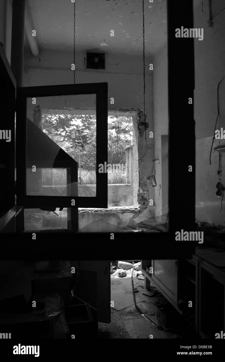 Rotture di telai di finestra e la bobina di nastro sul fabbrica abbandonata piano. In bianco e nero. Foto Stock