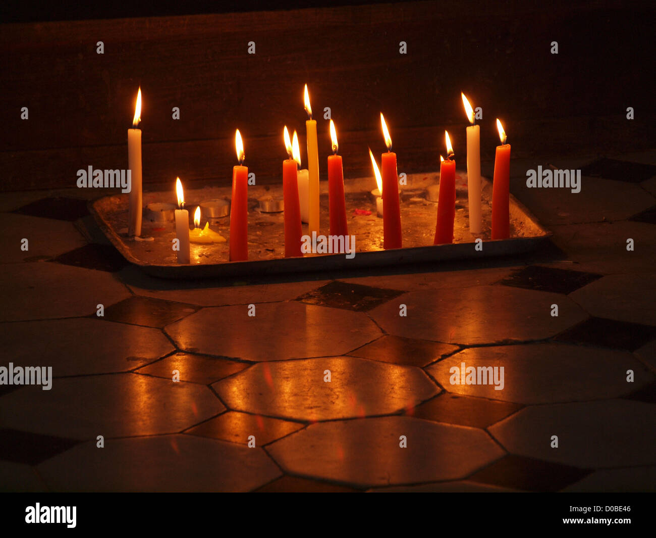 Il bianco e il rosso candele votive con riflessioni in lucido pavimento di piastrelle in Trinidad Cuba - Patrimonio mondiale dell UNESCO Foto Stock