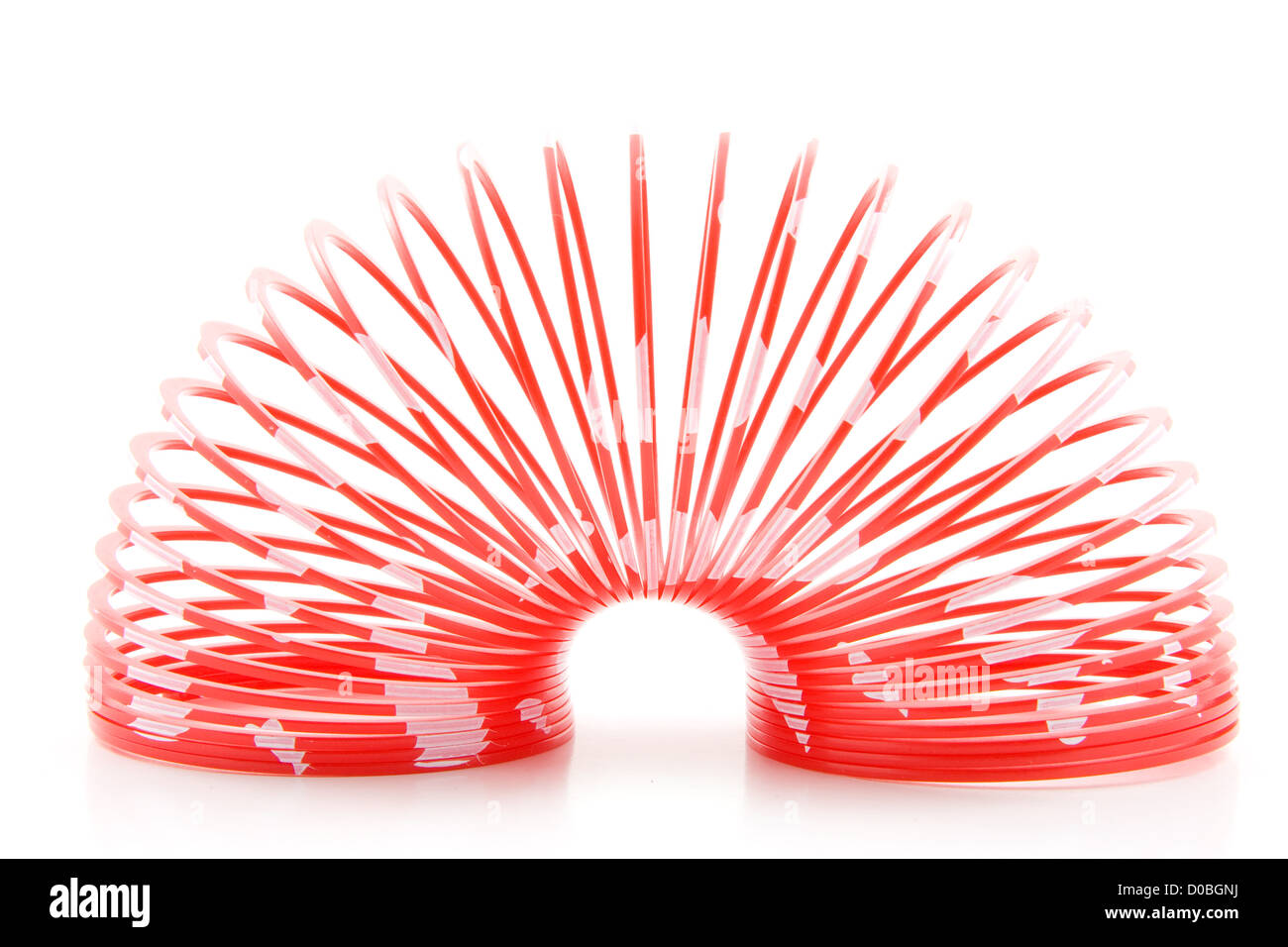 In plastica rosso giocattolo a molla isolati su sfondo bianco Foto Stock