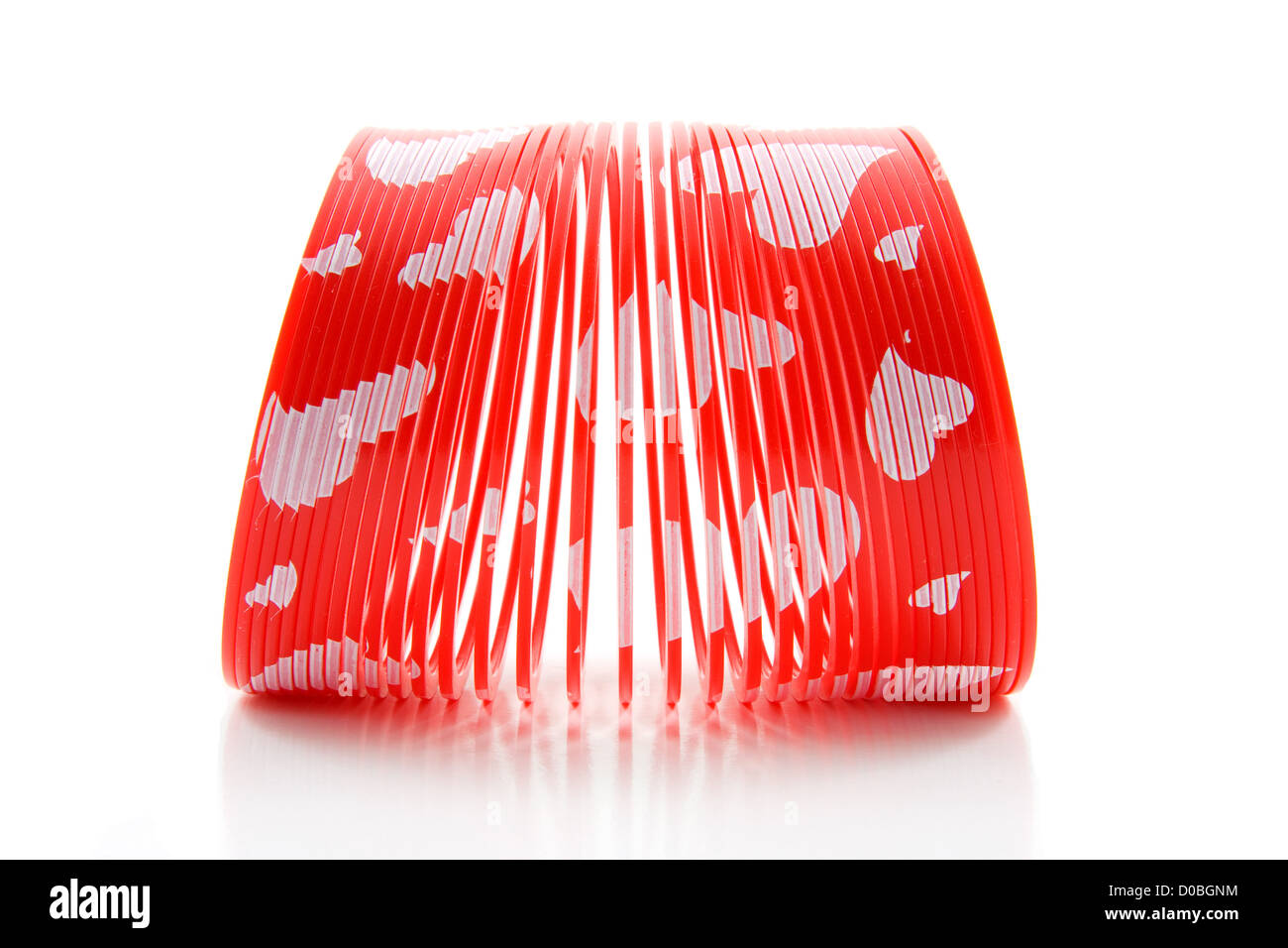 In plastica rosso giocattolo a molla isolati su sfondo bianco Foto Stock