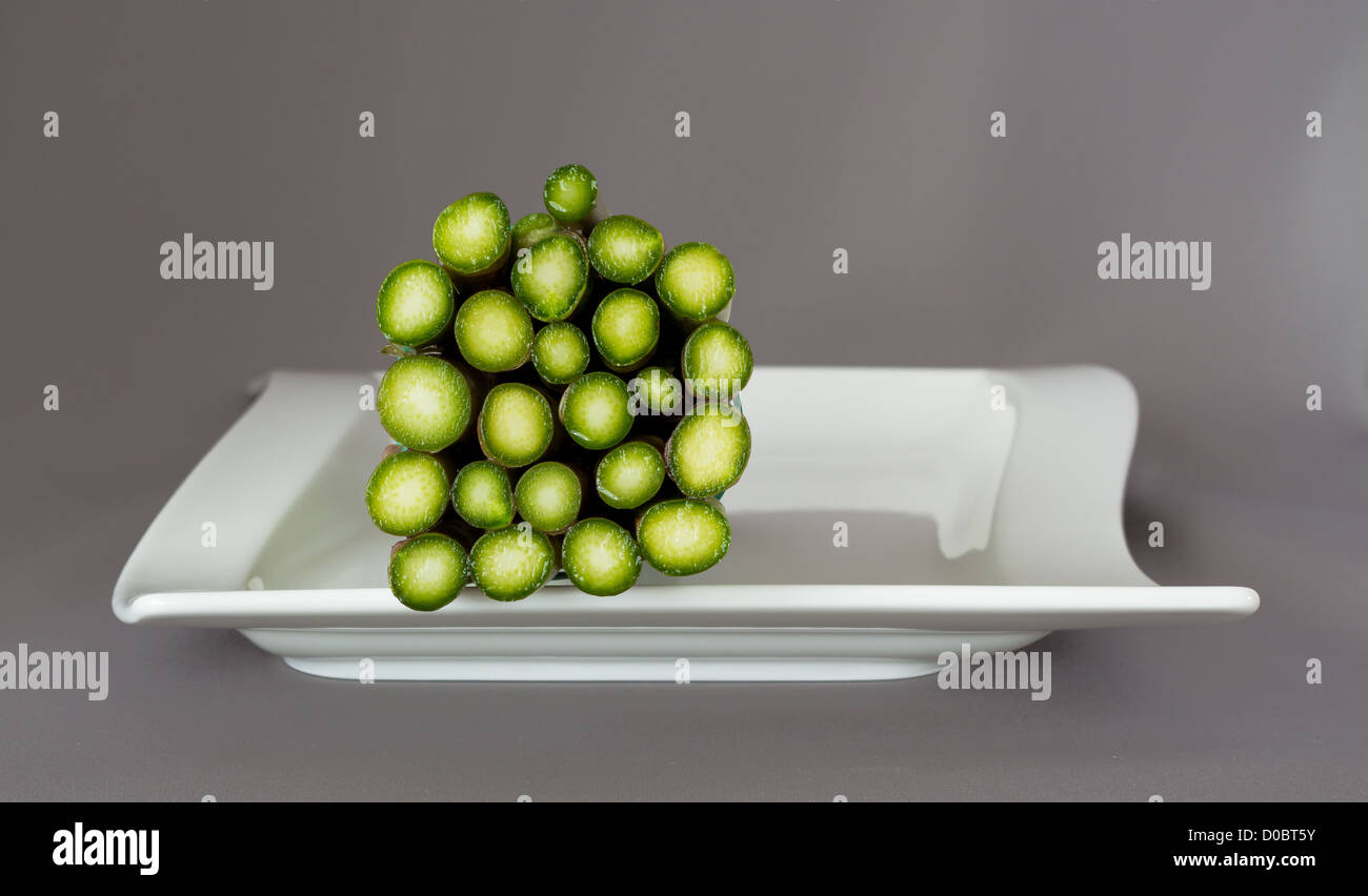 Fondo bagnato di un bundle di asparagi su un bianco piastra cena Foto Stock