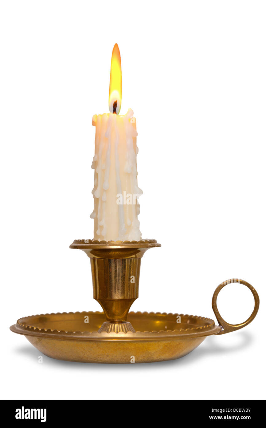 Un gocciolamento candela di cera combustione con fiamma in una tradizionale porta in ottone noto come un chamberstick, isolata su uno sfondo bianco. Foto Stock