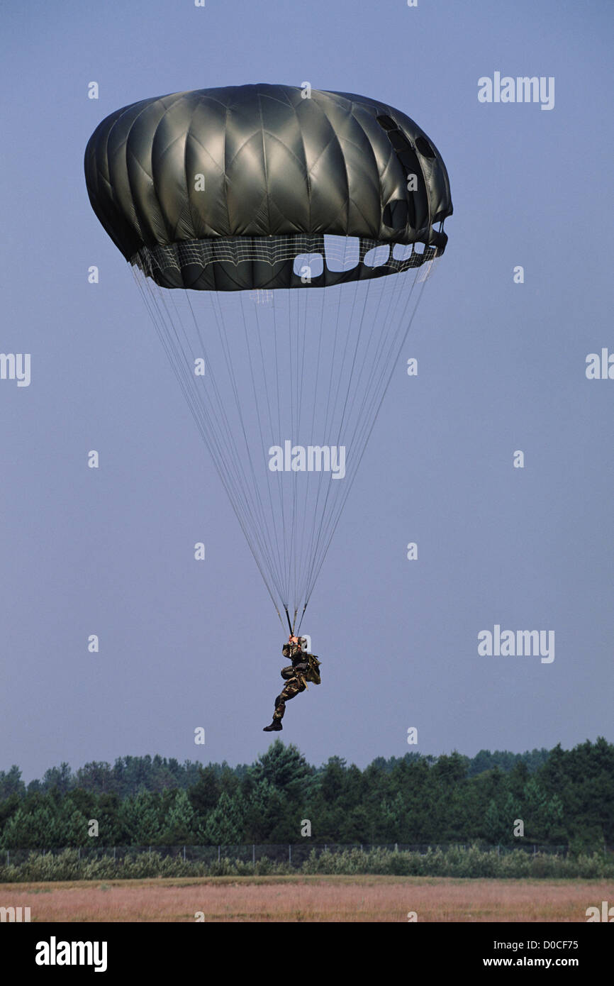 Parachutist militare si prepara a terra Foto Stock