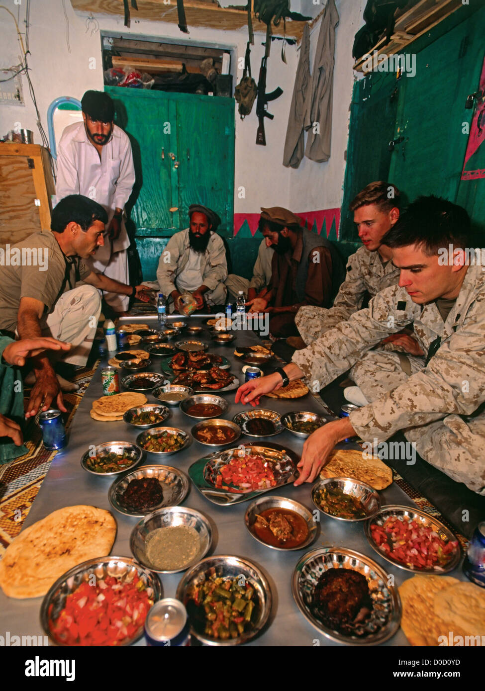 Marines americani per gustare la cena con locali combattenti afghani in Nangalam, Afghanistan Foto Stock