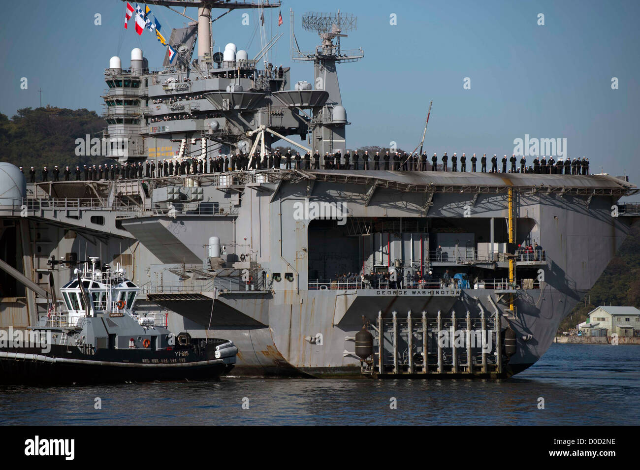 I marinai a bordo della USS George Washington (CVN 73) manovrano i binari mentre la nave torna a Yokosuka, in Giappone, fornendo supporto operativo con il Carrier Air Wing 5 per le operazioni di difesa e sicurezza marittima. Foto Stock