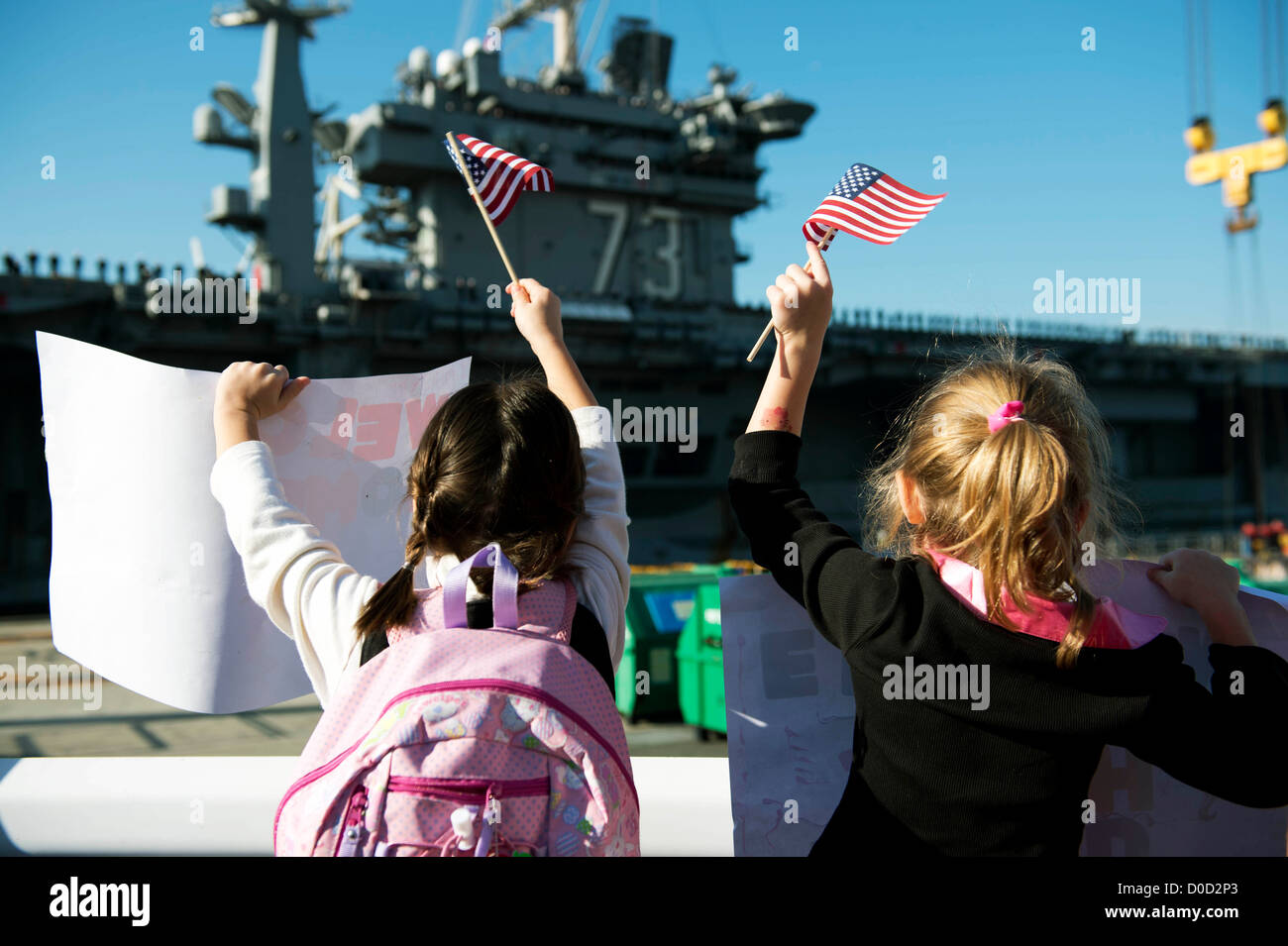 Membri della famiglia di velisti assegnati alla Nimitz-class portaerei USS George Washington (CVN 73) raccogliere per salutare la nave Foto Stock