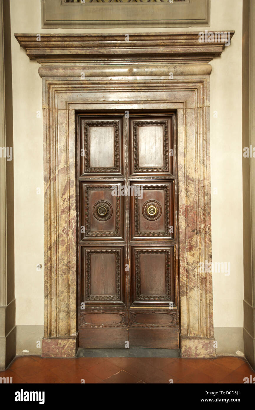 Vecchia porta di legno con ornati architrave in marmo nel Pallazzo Veccio Firenze Toscana Italia Foto Stock