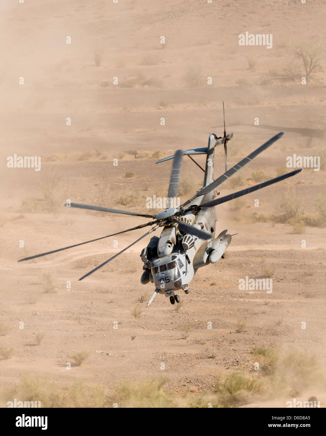 Un U.S. Marine Corps CH-53E rende un polveroso il decollo da un deserto zona di atterraggio Foto Stock
