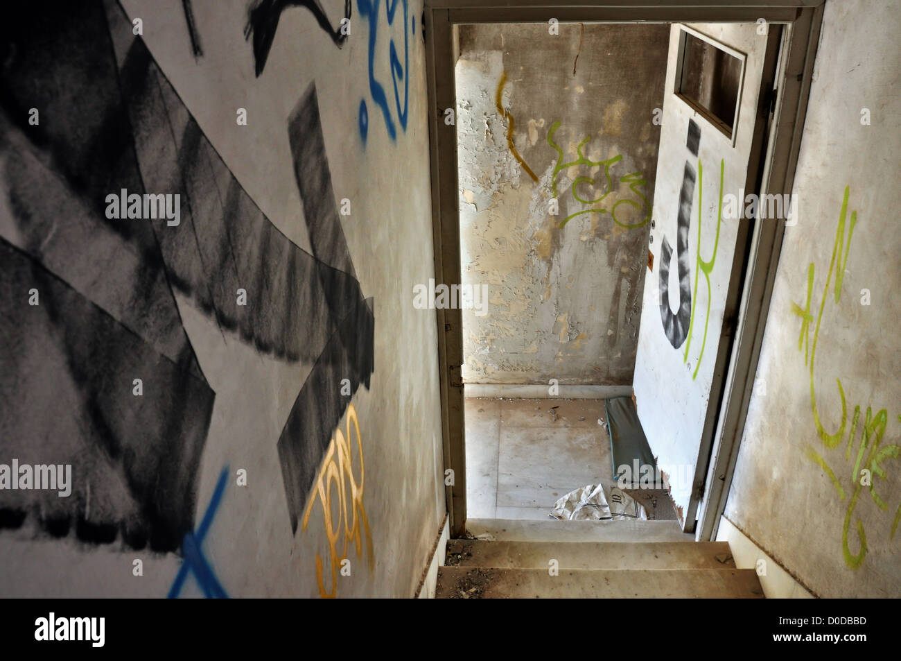 Dipinto di freccia sulla scalinata puntando alla porta di uscita in una casa abbandonata. Foto Stock