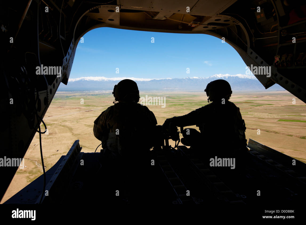 Army Air equipaggio profilarsi nel retro di un CH-47 Chinook volando verso Kabul Foto Stock