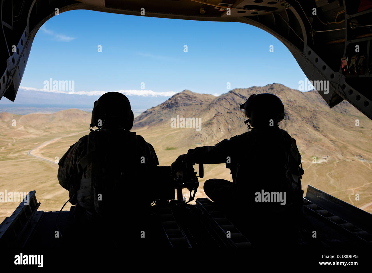 Army Air equipaggio profilarsi nel retro di un CH-47 Chinook volando verso Kabul Foto Stock