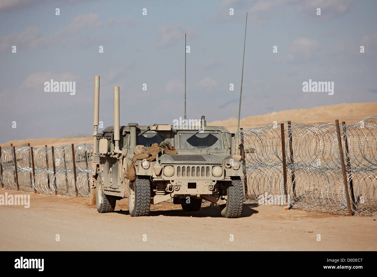 Un U.S. Marine Corps HMMWV o Humvee, parcheggiata accanto al filo di concertina, Camp Bastion, provincia di Helmand, Afghanistan. Foto Stock