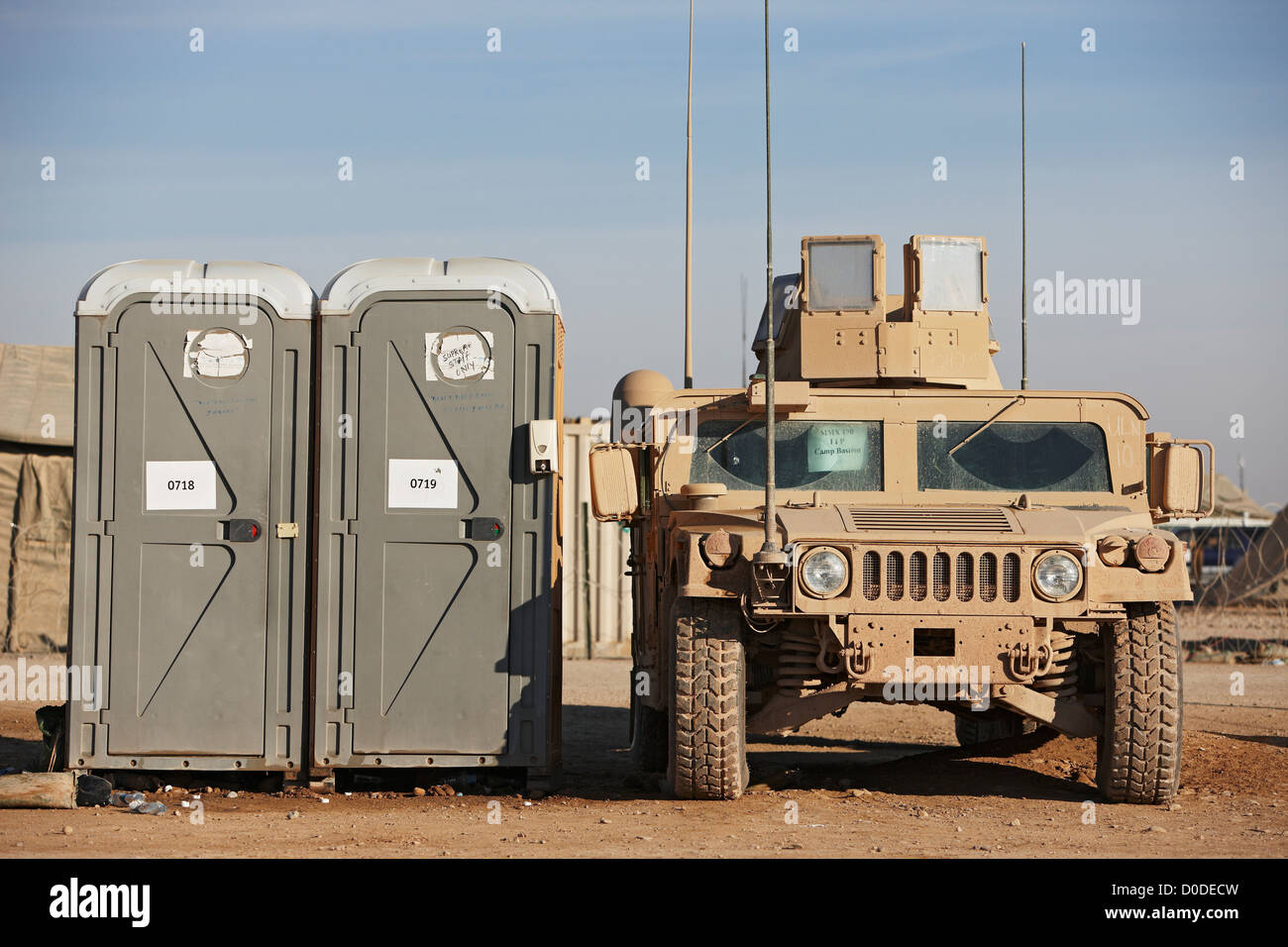 Un U.S. Marine Corps HMMWV parcheggiato di fianco a due bagni portatili, Camp Leatherneck, provincia di Helmand, Afghanistan. Foto Stock