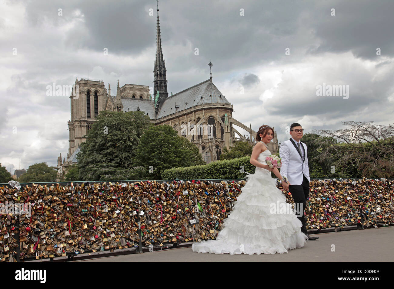 Foto di matrimonio giapponese COPPIA DI FRONTE amore i lucchetti sul PONT DE L'ARCHEVECHE BRIDGE la cattedrale di Notre Dame a Parigi in background Foto Stock